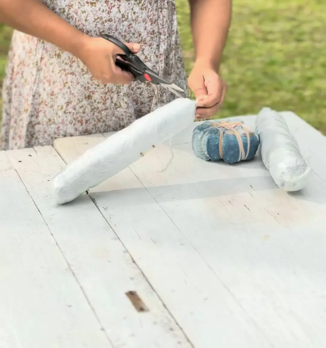 A steamed bundle is cut open with scissors.