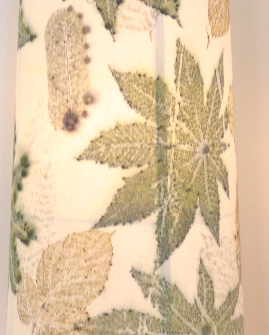 Leaf prints on the lamp shade, lit warmly from within.