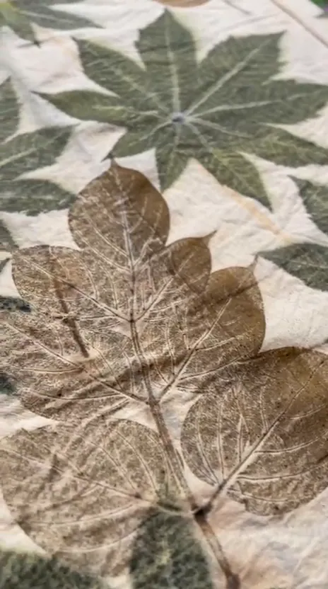 A slow look across palmate-leaf prints in sage, olive and umber on cream cloth.