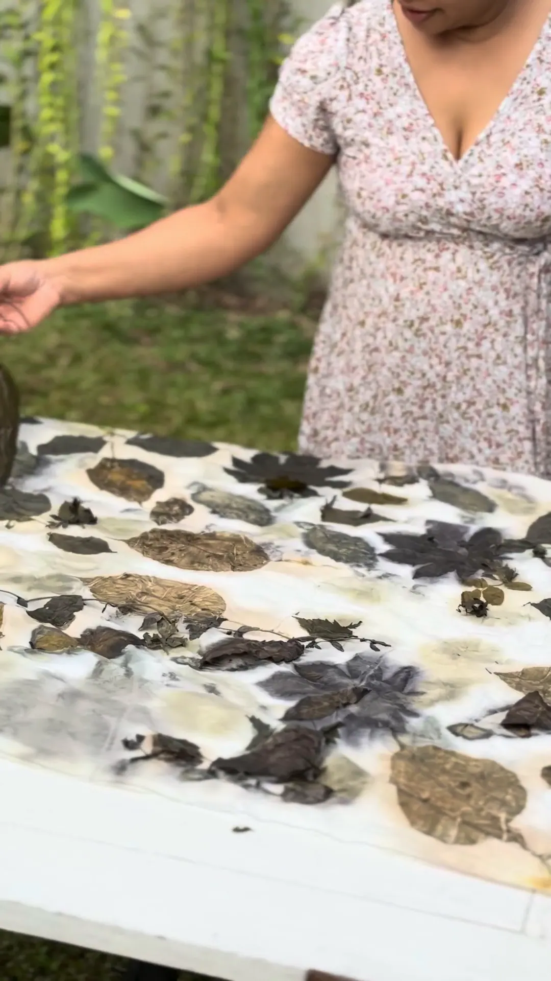 Steamed leaves are peeled away from a cloth printed in umber, olive and charcoal.