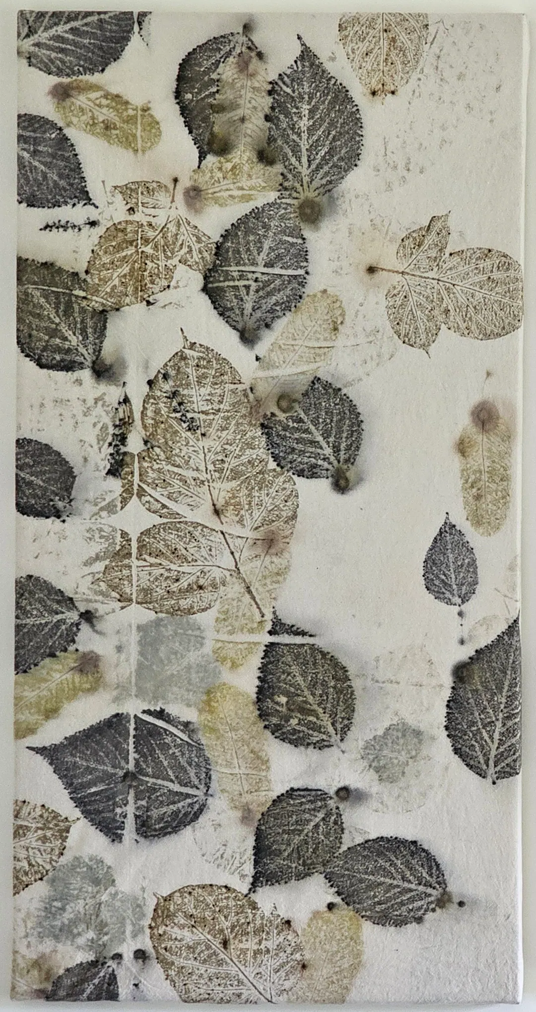 Ivory panel printed with charcoal, olive and stone-coloured leaves, flecked with small dark dots of colour.