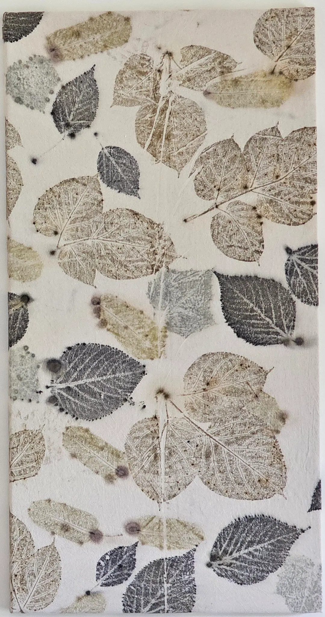 Pale panel printed with slate-grey and soft brown leaf impressions.